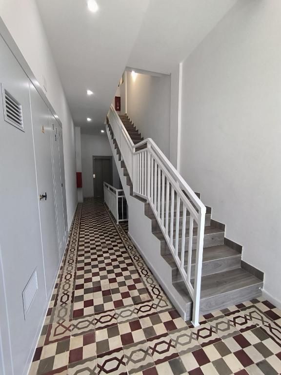 Un pasillo con escaleras y suelo cuadriculado.