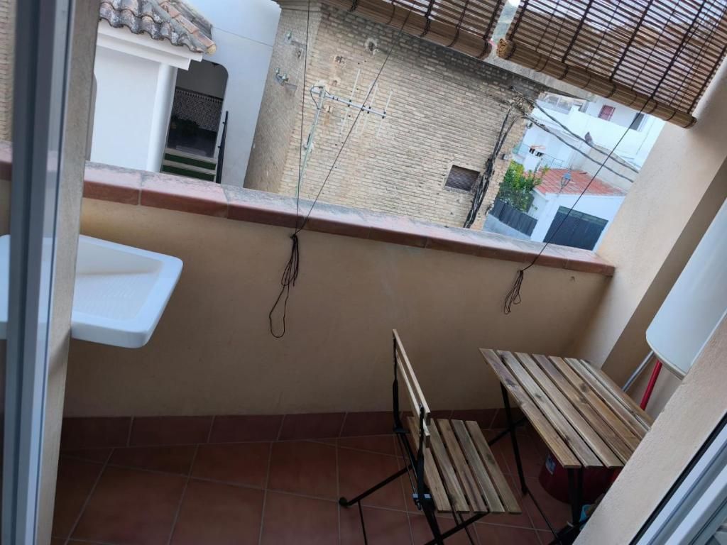 Un balcón con una mesa y sillas y un lavabo.