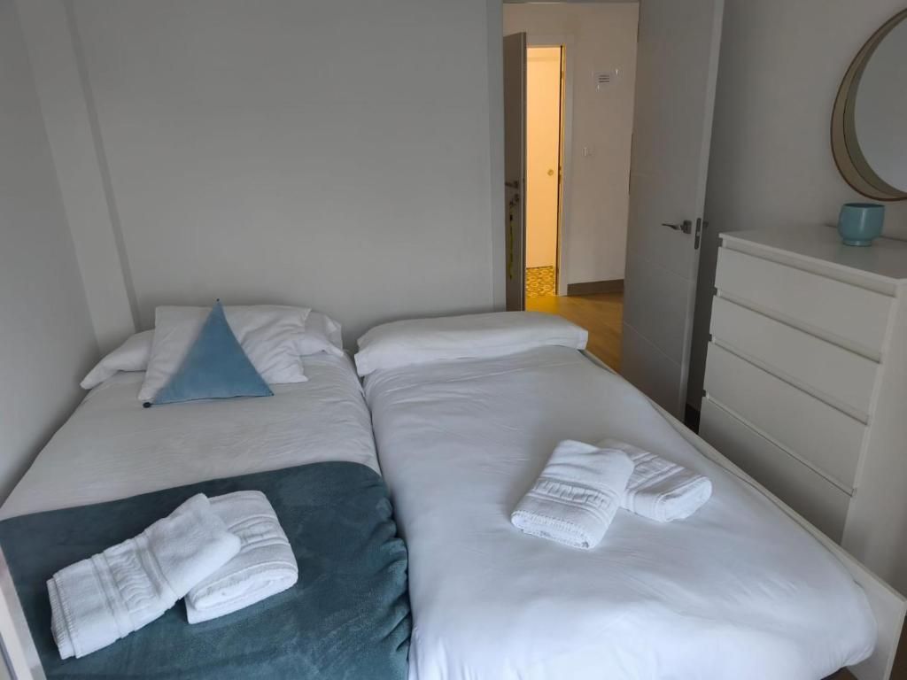 Un dormitorio con dos camas, una cómoda y un espejo.