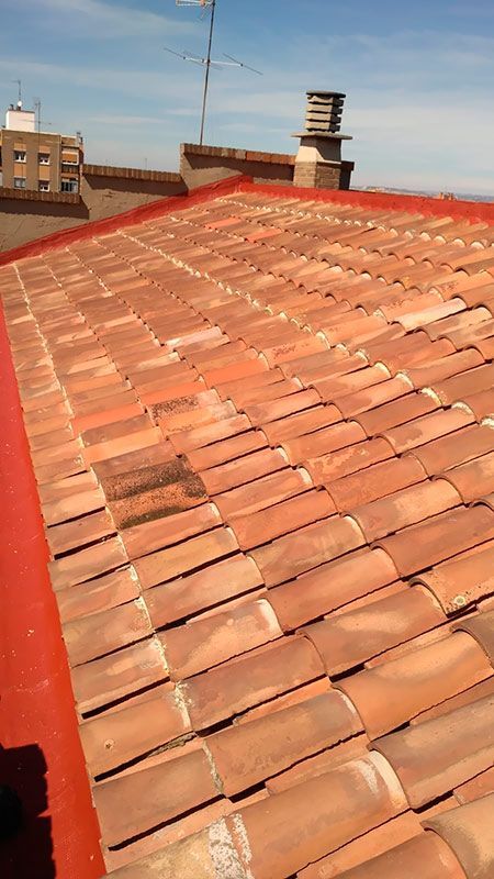 Un primer plano de un techo de tejas con un borde rojo.