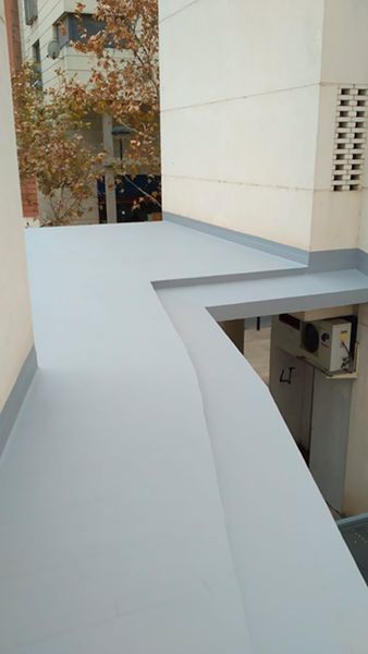 Un balcón en el lateral de un edificio con techo blanco.