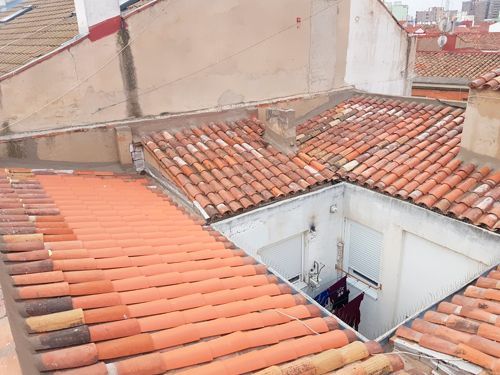 Un techo con tejas rojas y un desagüe.