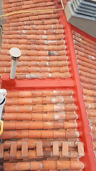 Un techo con tejas rojas y una chimenea sobre él.