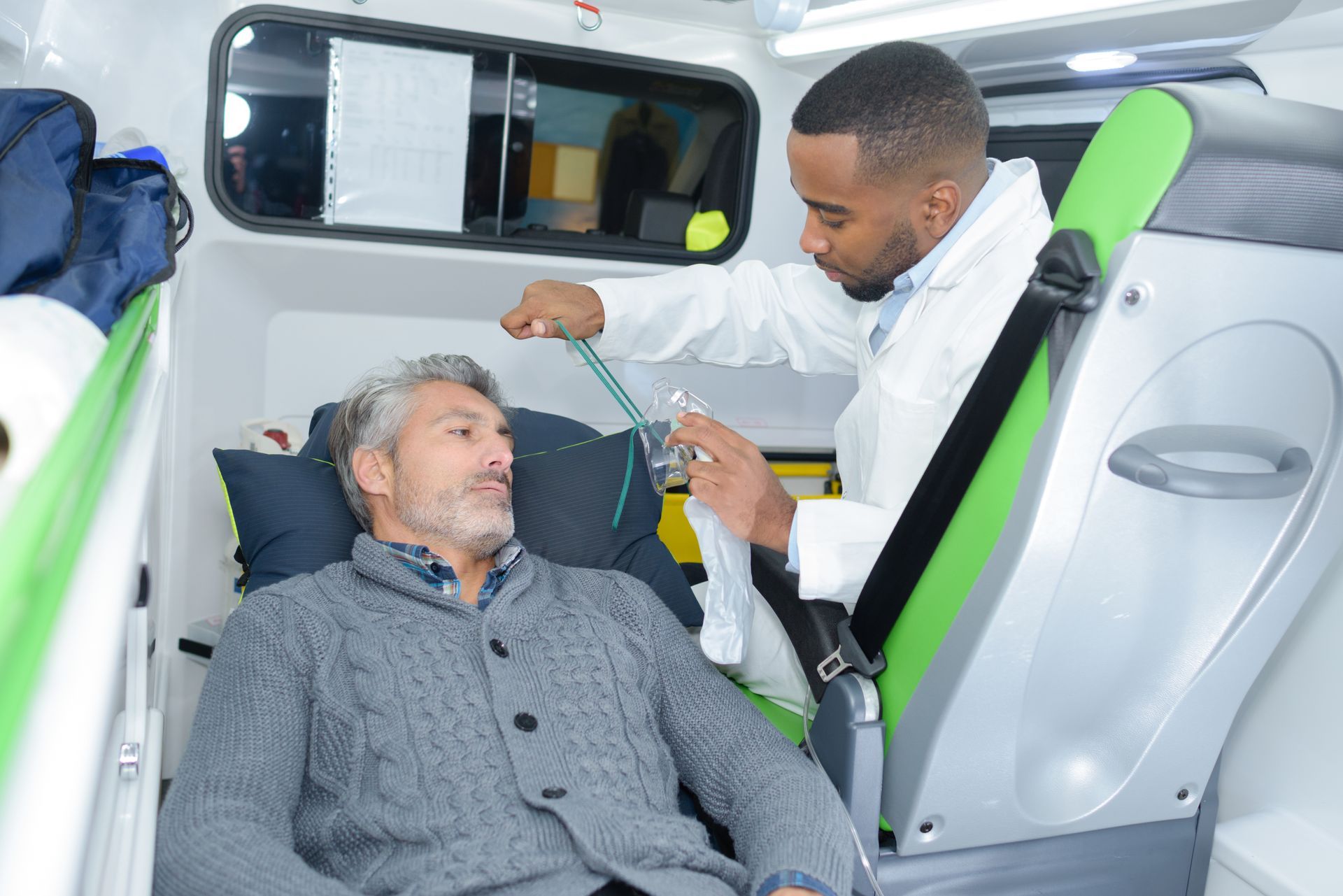 Un homme dans une ambulance reçoit des soins médicaux de la part d'un professionnel de santél.