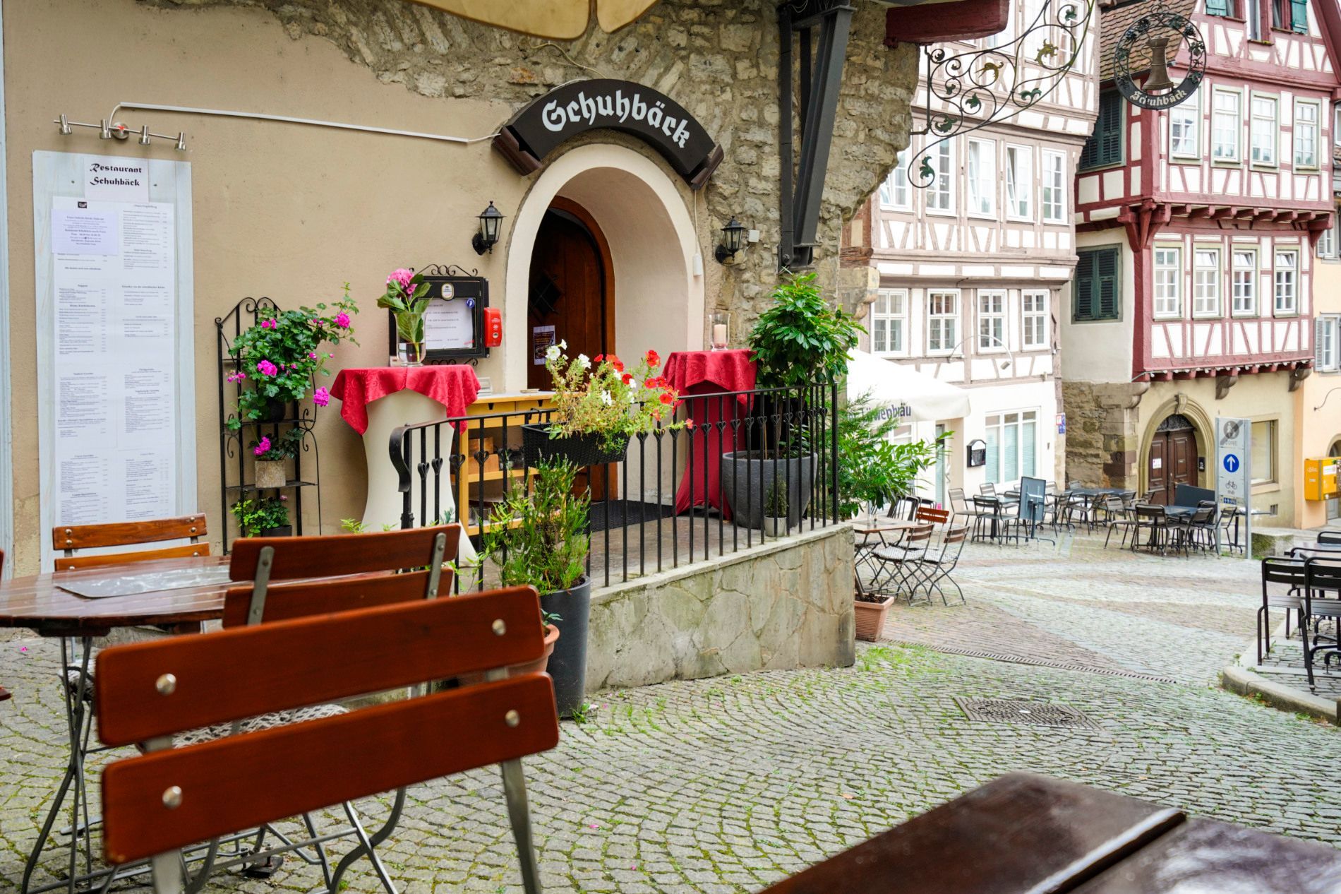 Draußen vor dem Restaurant Schuhbäck stehen Tische und Stühle.