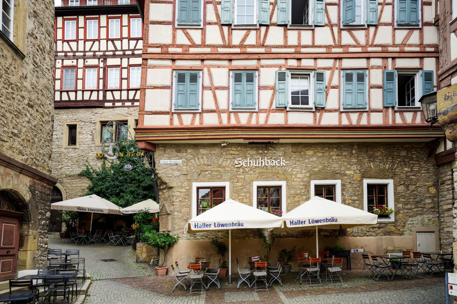 Ein Restaurant mit Tischen und Sonnenschirmen vor einem Gebäude.