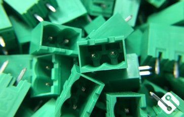 Una pila de conectores de plástico verde con la letra u en la parte inferior