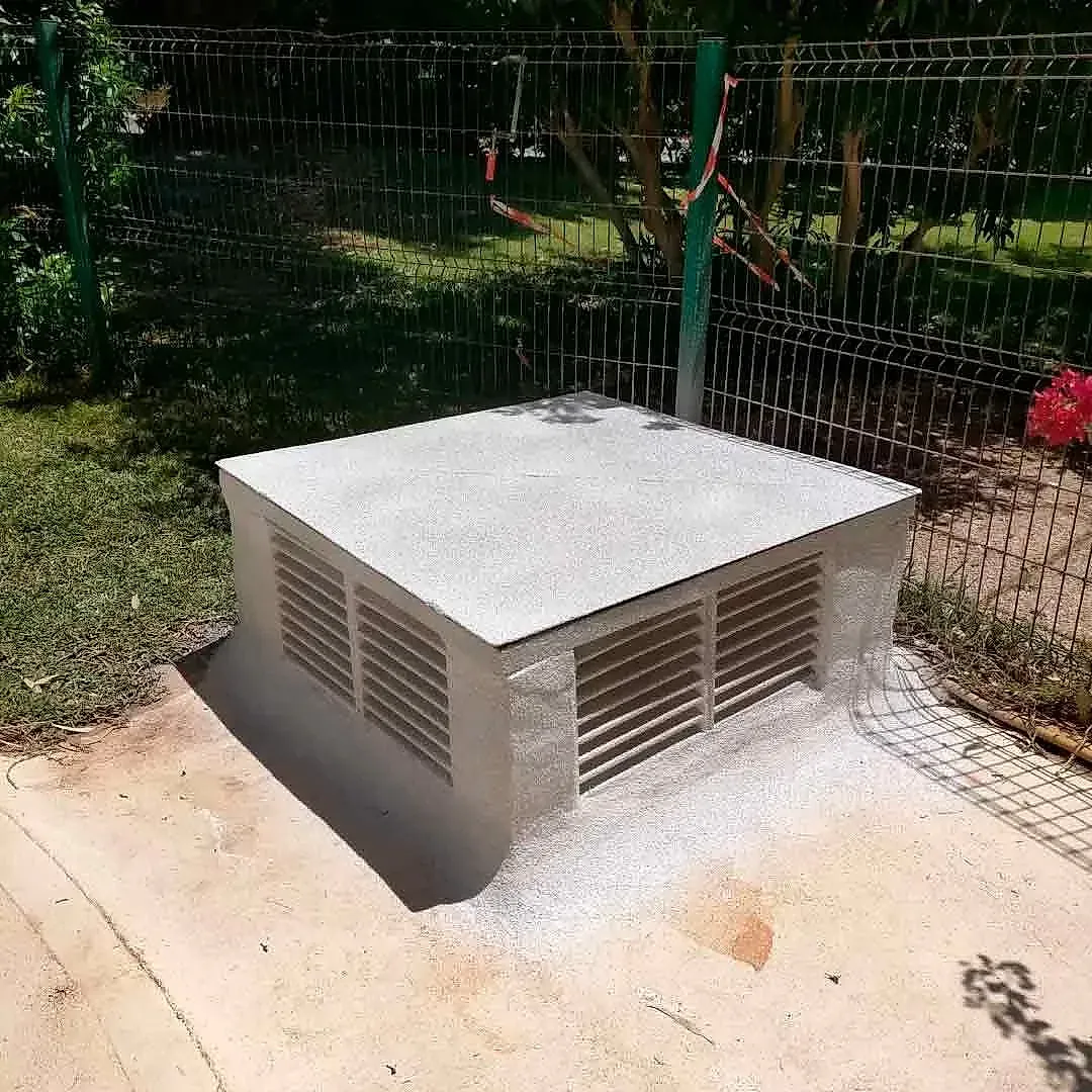 Una pequeña caja está en el suelo al lado de una valla.