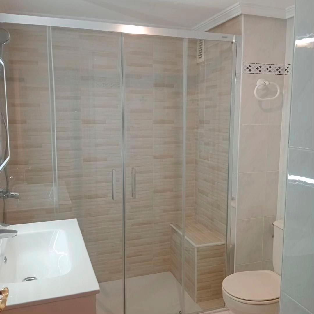 Un baño con inodoro, lavabo y ducha.