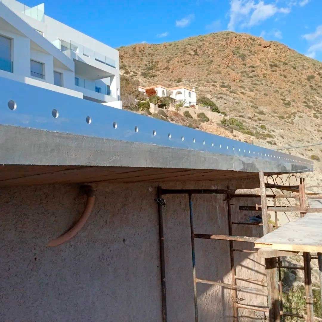 Un edificio en construcción con una montaña al fondo.