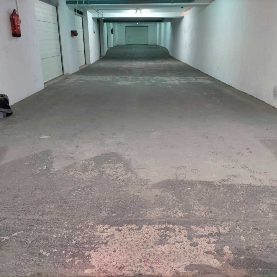 Un estacionamiento vacío con un extintor de incendios en la pared.