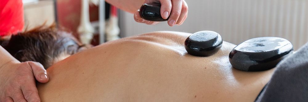 Eine Frau bekommt eine Hot-Stone-Massage auf dem Rücken.