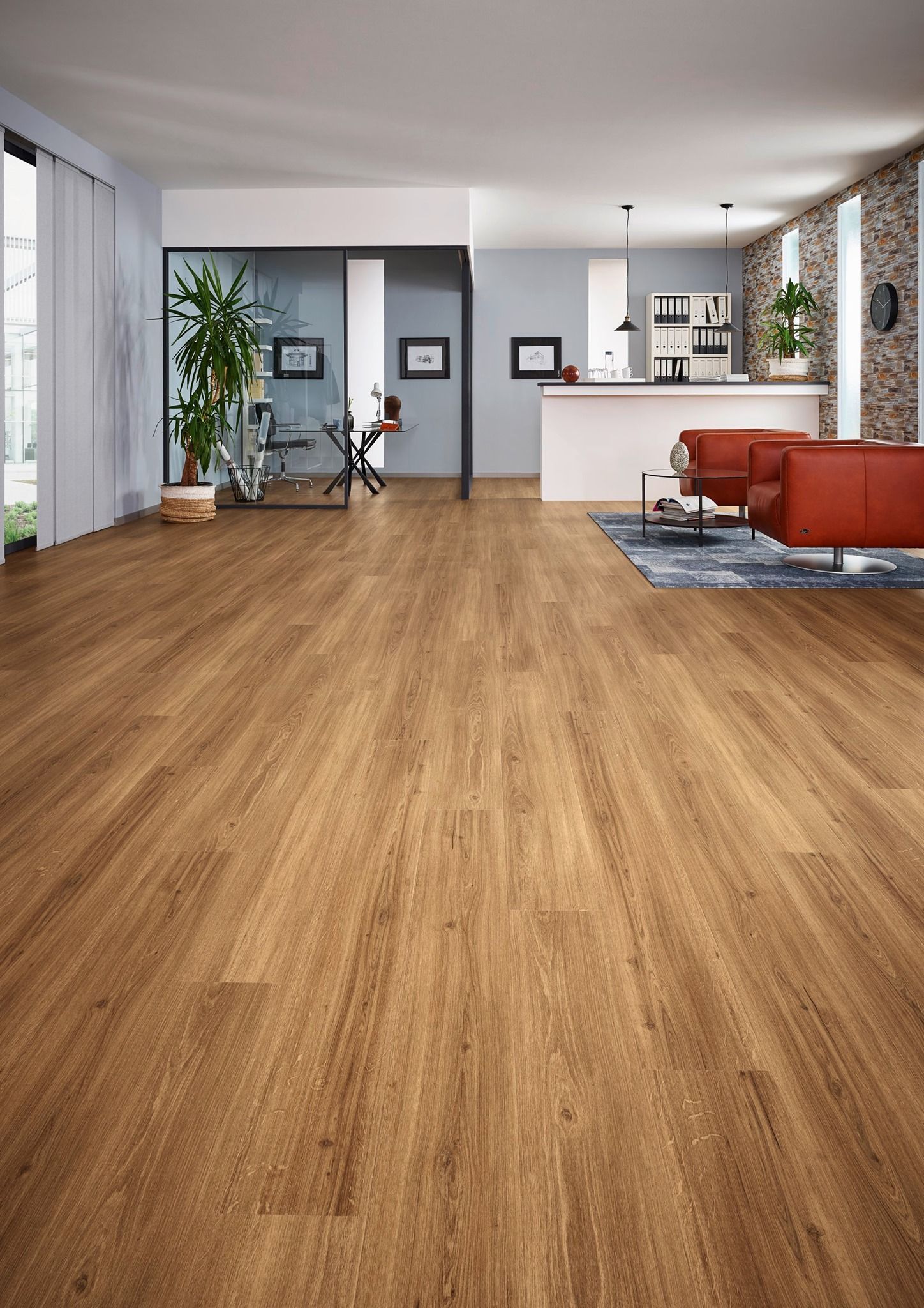 Holzboden in einem modernen Wohnzimmer mit rotem Ledersofa und Küche im Hintergrund.