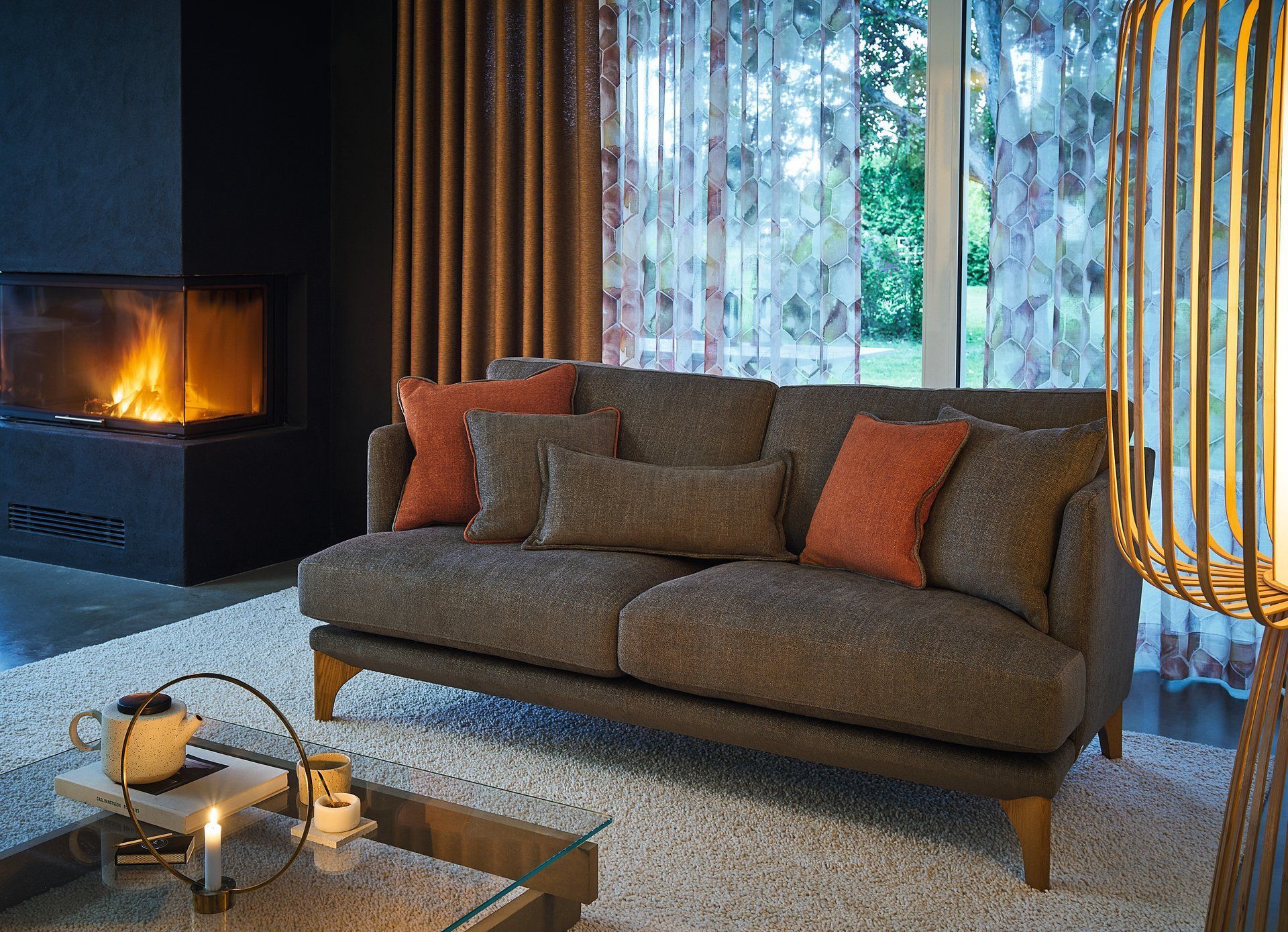 Gemütlicher Veranda-Innenraum mit geblümtem Sessel, Hocker und türkisfarbener Kommode; verwitterte Türen und Fenster.