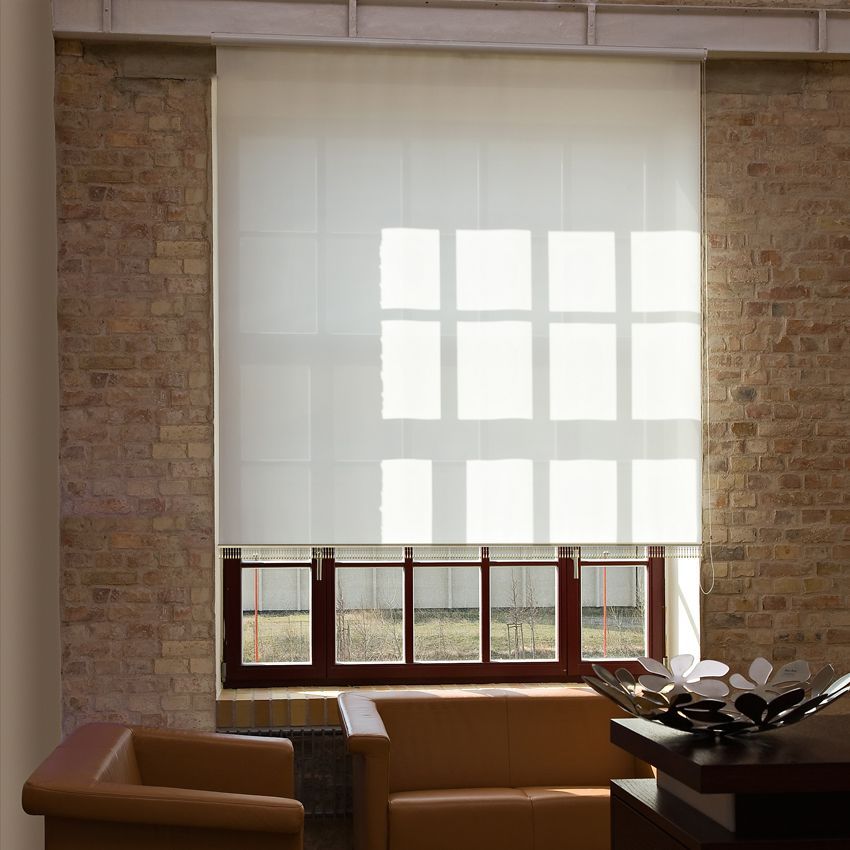 Fenster mit weißen Jalousien, Backsteinwand und braunen Möbeln. Licht fällt durch das Fenster.