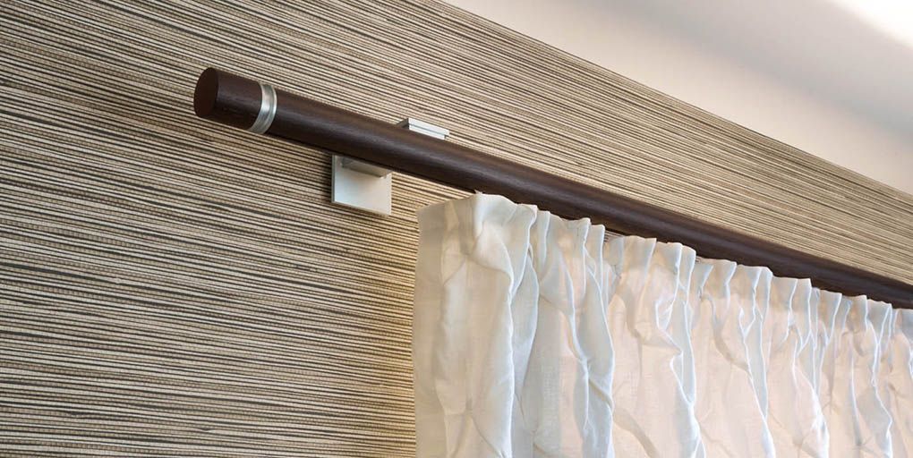 Gemütlicher Veranda-Innenraum mit geblümtem Sessel, Hocker und türkisfarbener Kommode; verwitterte Türen und Fenster.