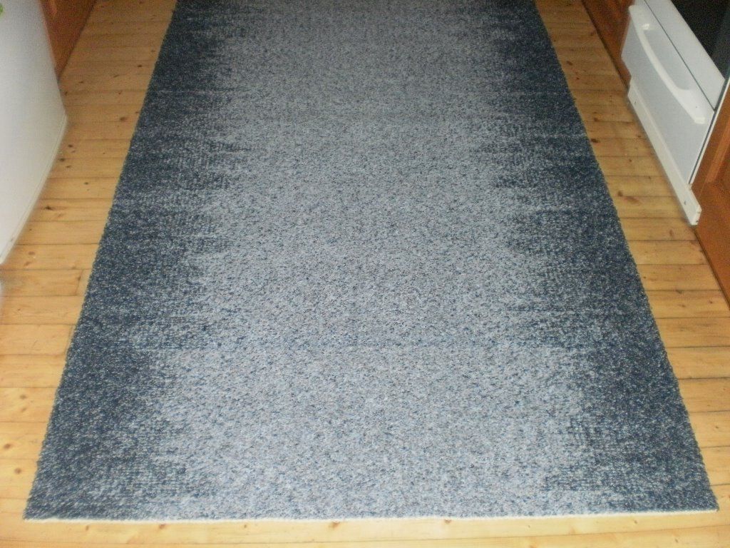 Harmaa matto makaa puulattialla