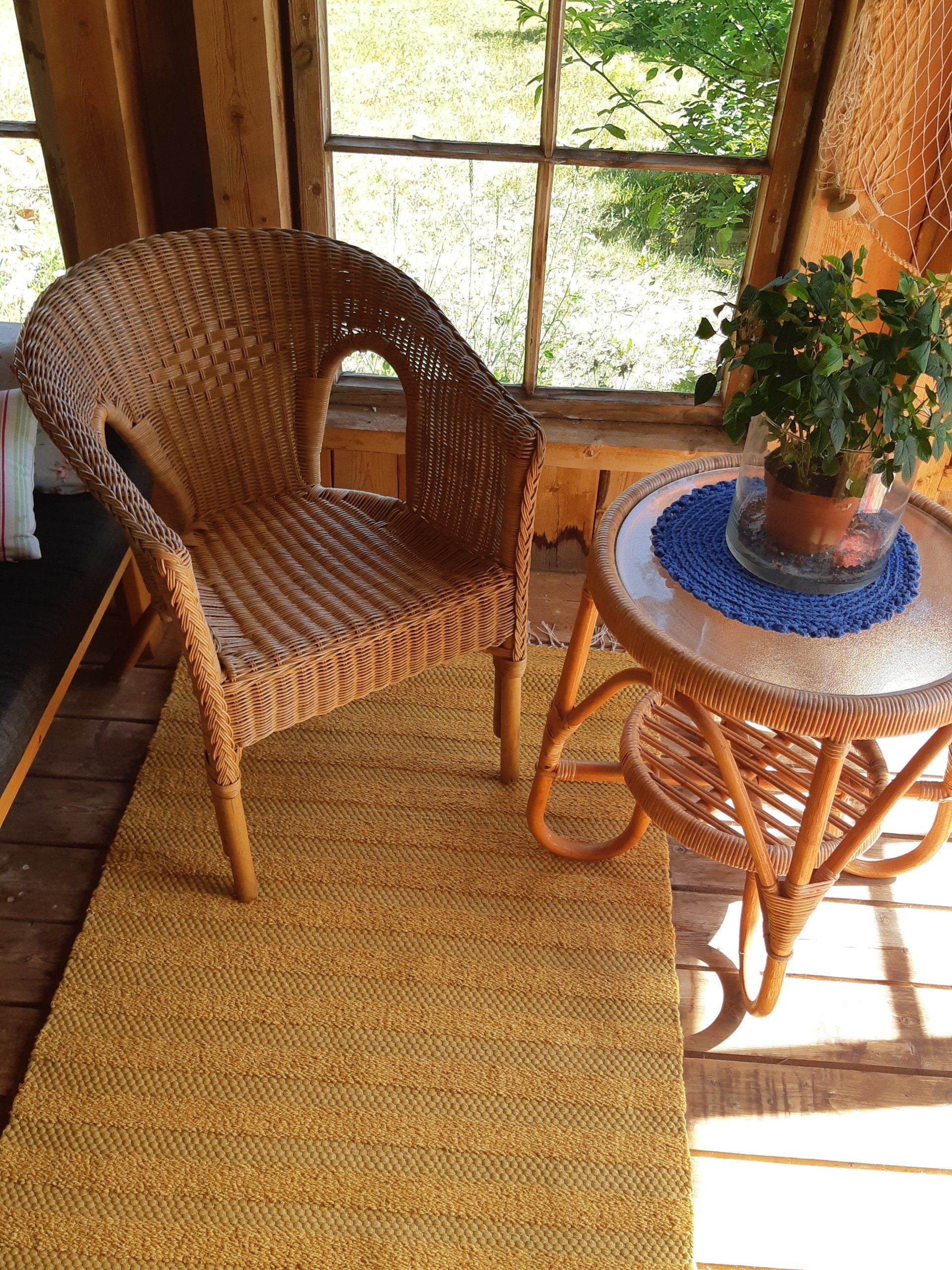 Rottinkituoli on ikkunan edessä pöydän vieressä