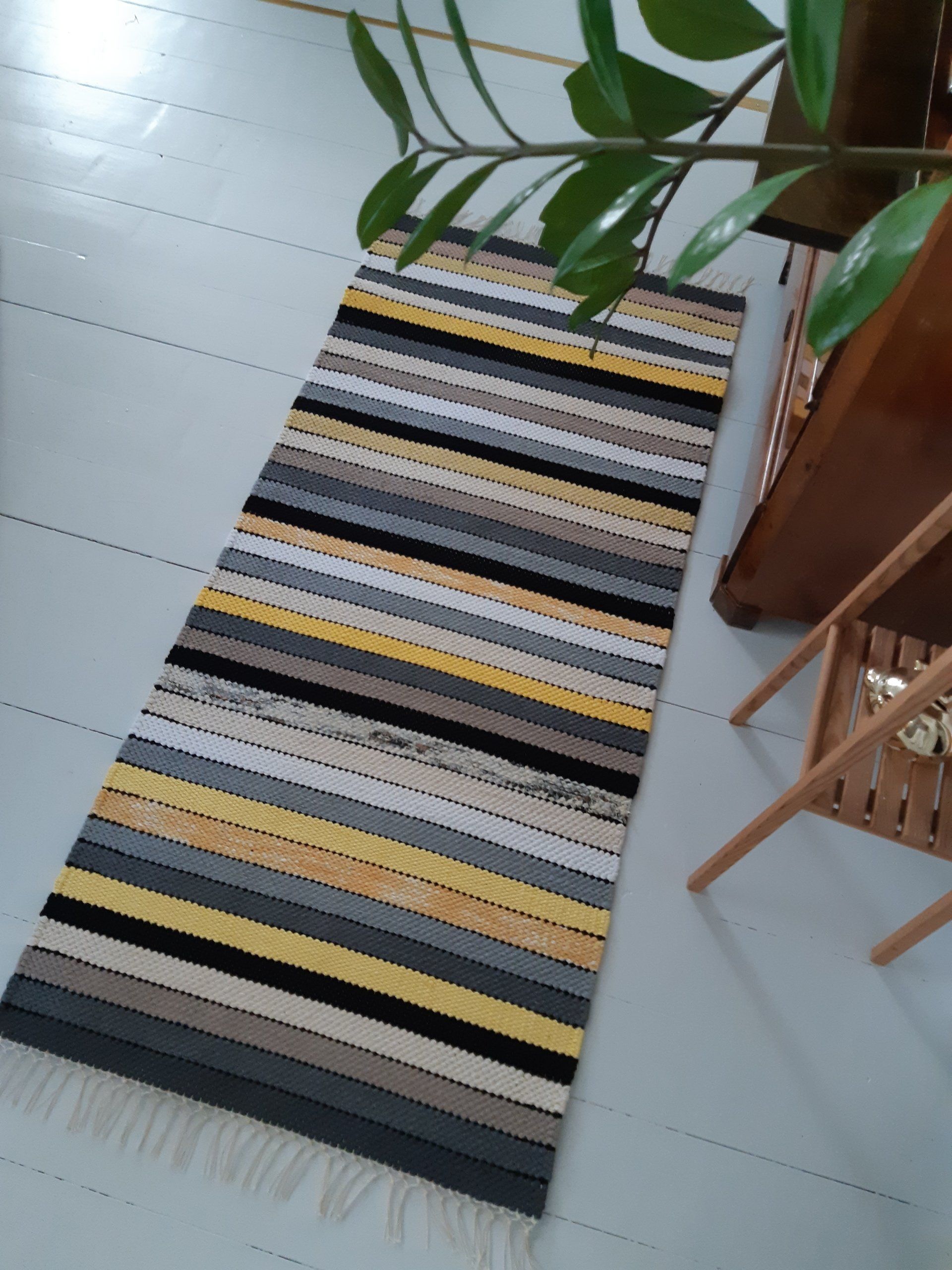 Raidallinen matto on lattialla kasvin vieressä