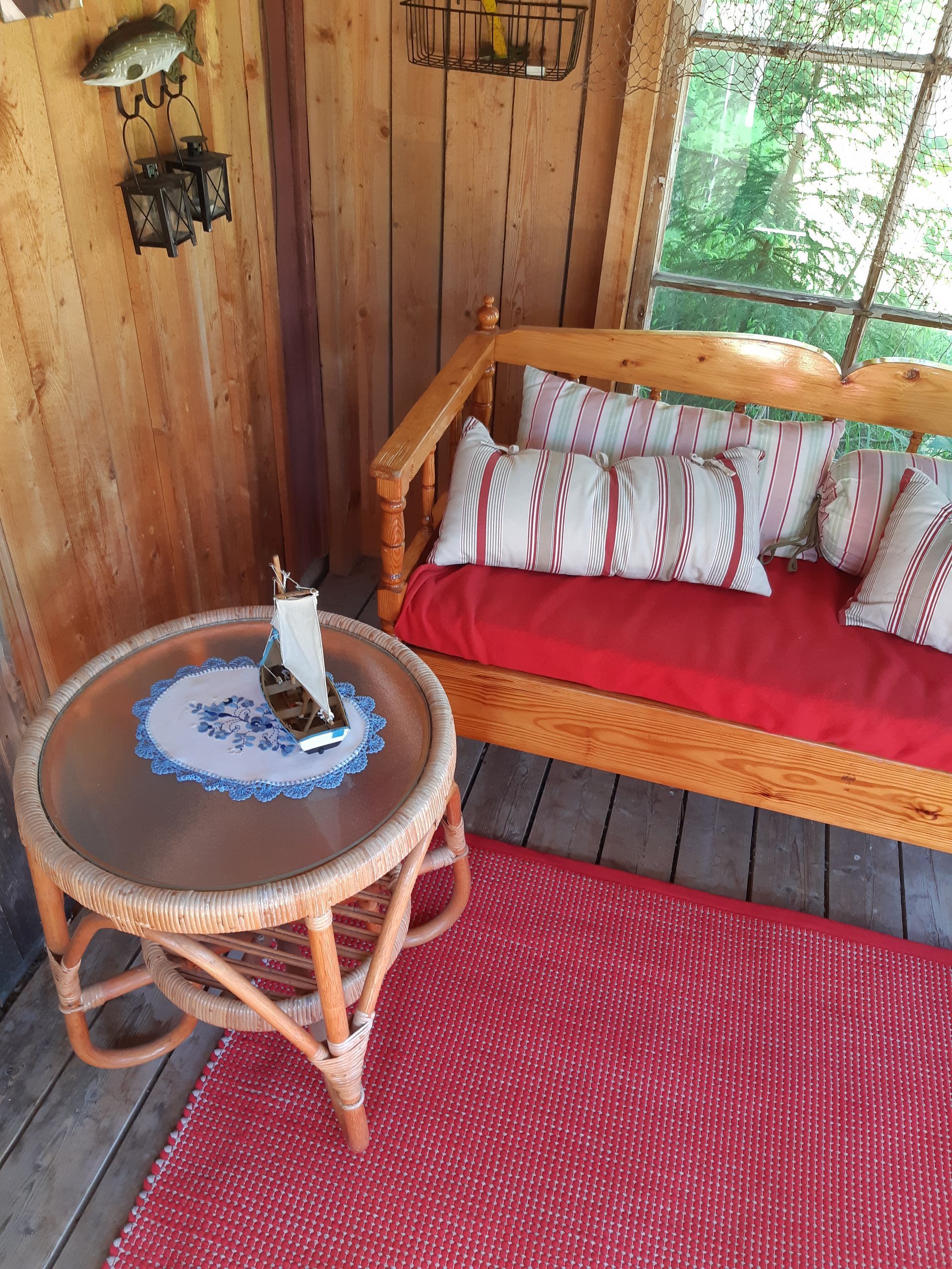 Sohvan vieressä on pöytä, jolla on purjevene