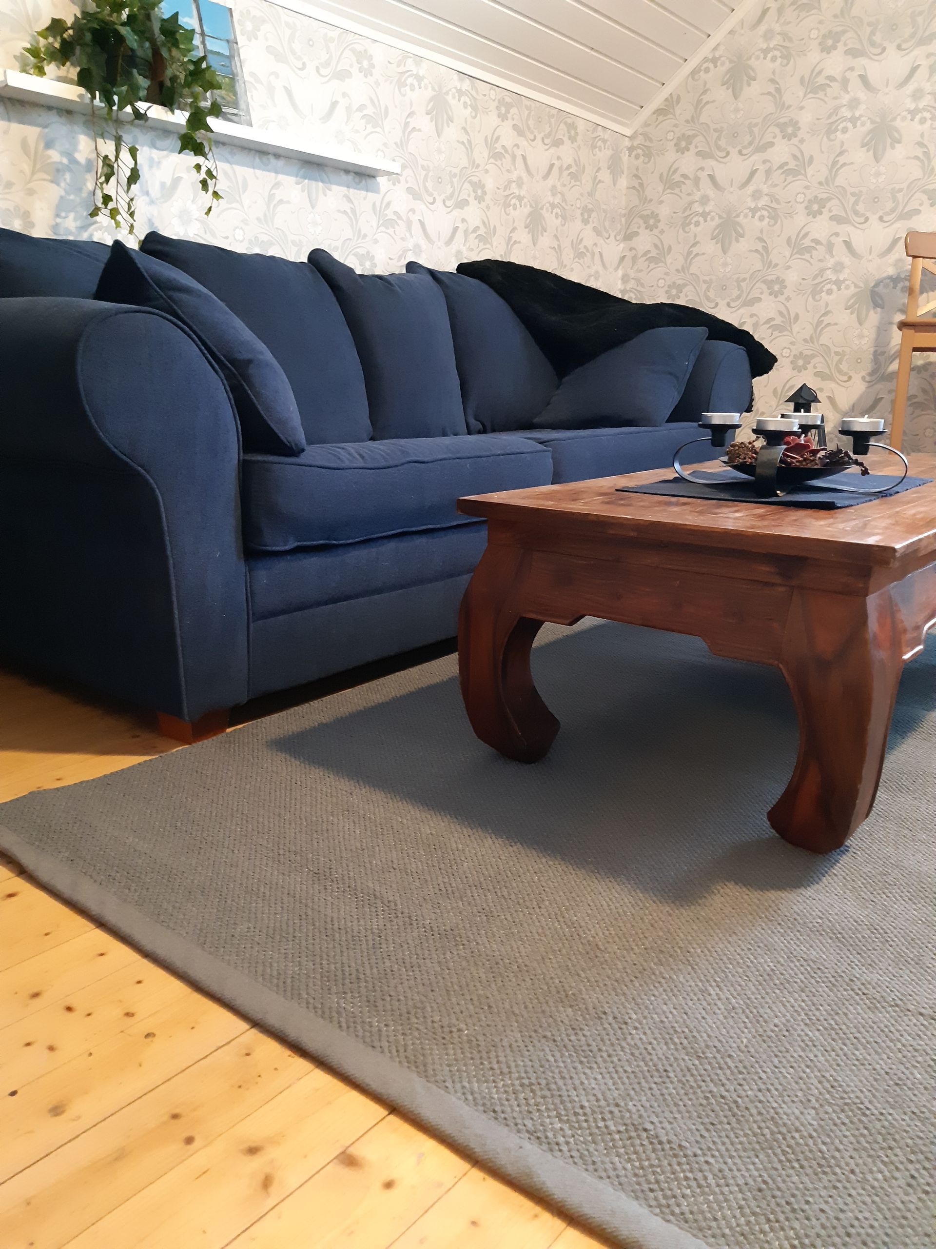Olohuone, jossa on sininen sohva ja puinen sohvapöytä