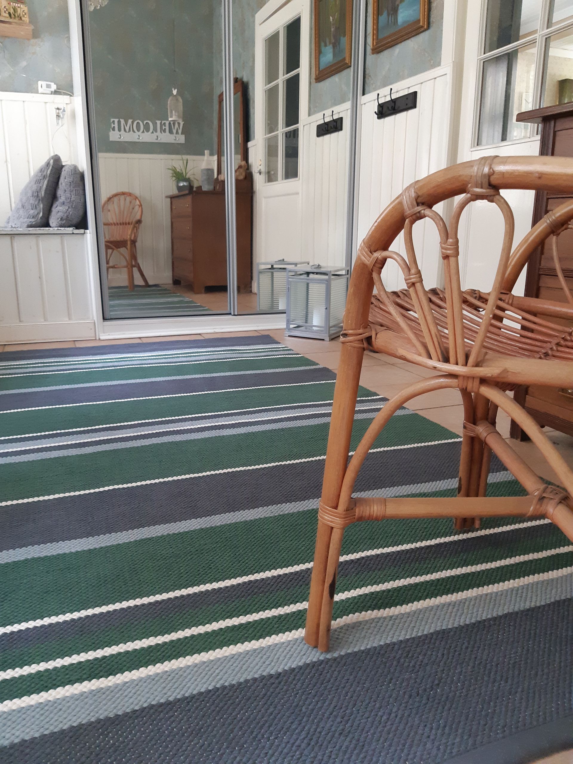 Rottinkituoli on raidallisella matolla olohuoneessa