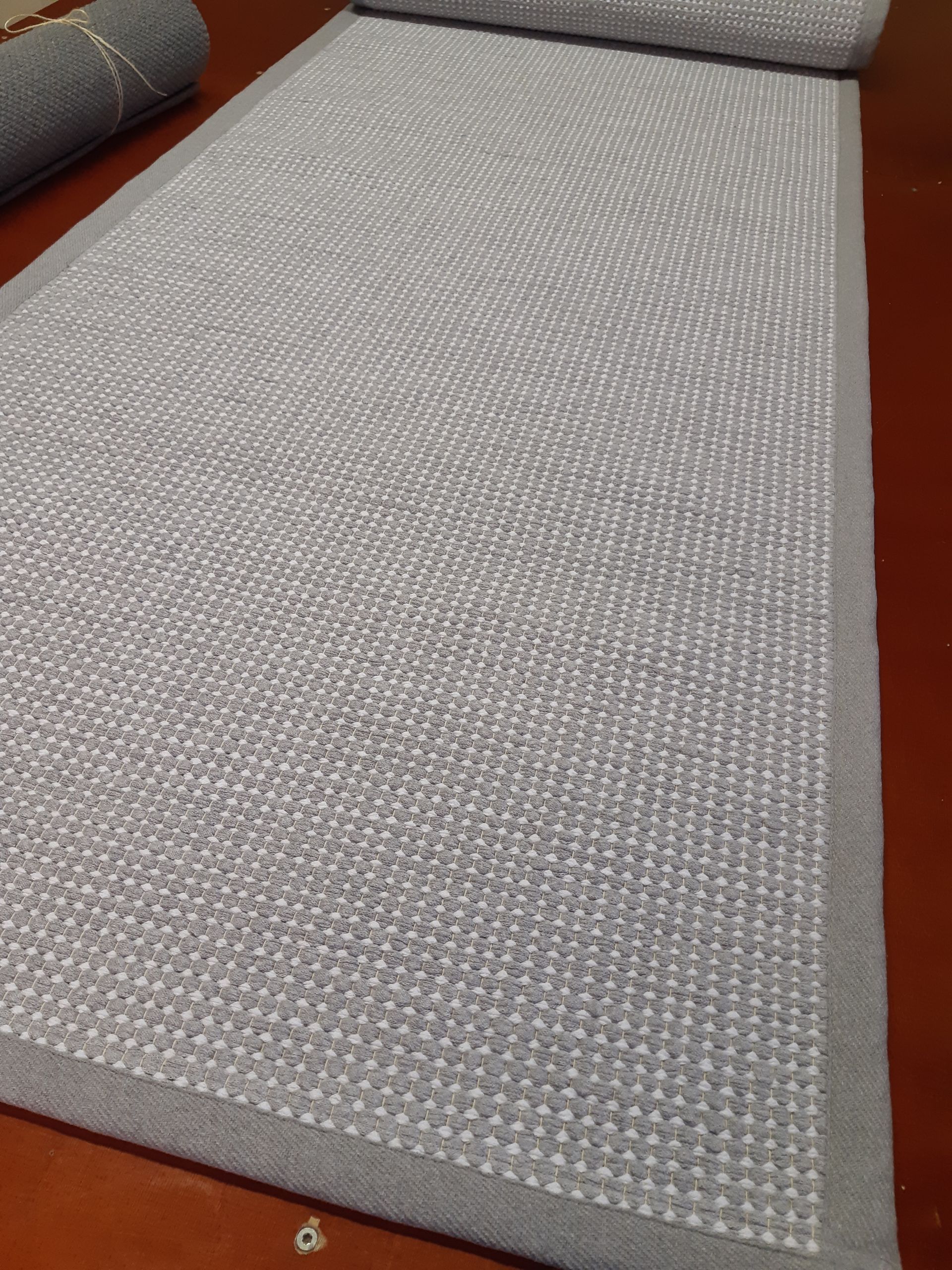 Harmaa matto lepää puisella pöydällä