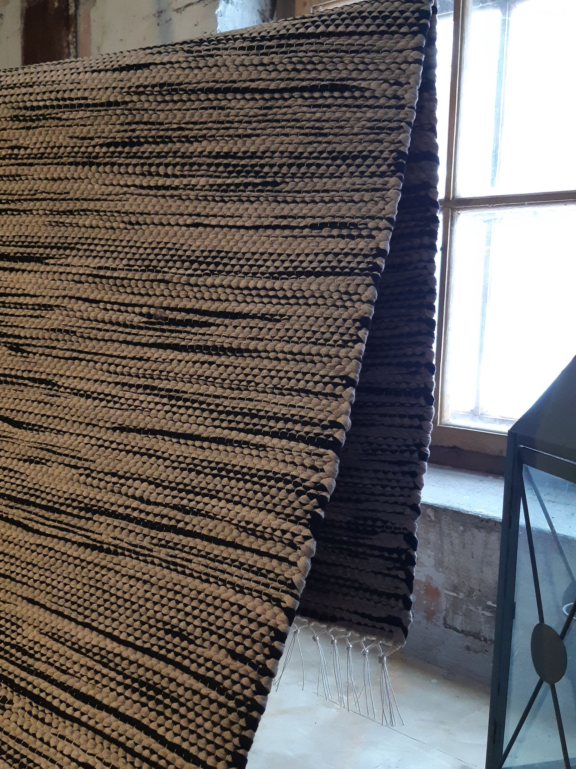 Mustavalkoinen matto on lattialla ikkunan edessä