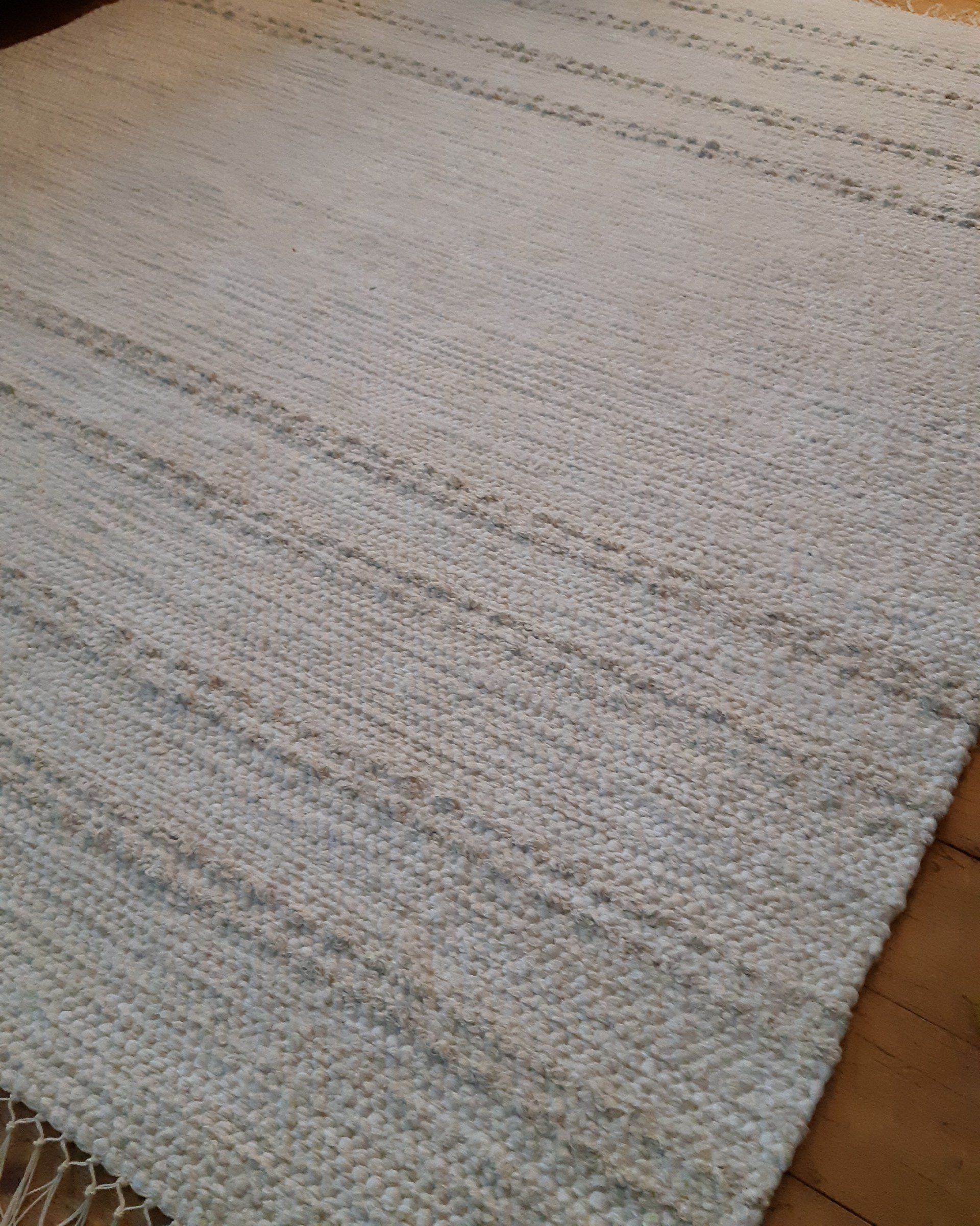 Valkoinen matto on puulattialla