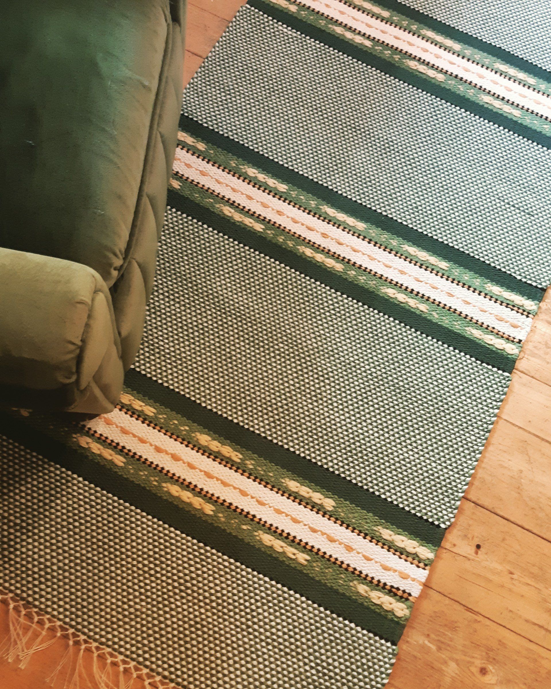 Vihreä tuoli on vihreän ja valkoisen maton vieressä