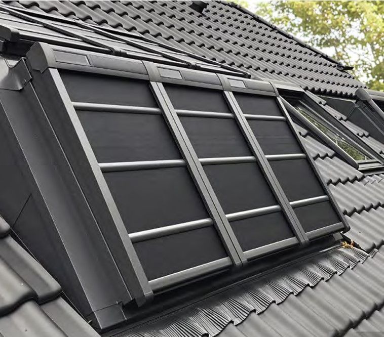 Mehrere Dachfenster mit teilweise geschlossenen Außenrollos auf Schrägdach.