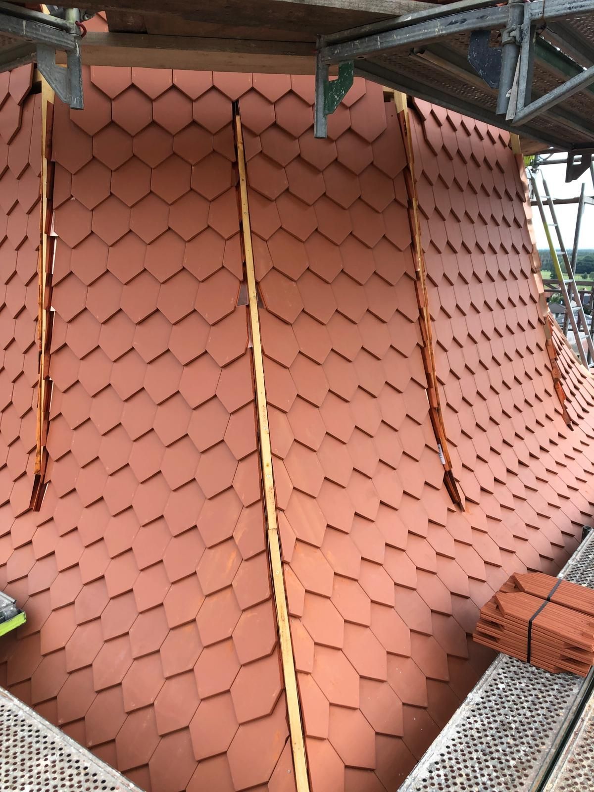 Detailansicht einer Dachdeckung mit roten Biberschwanzziegeln und Gerüstkonstruktion