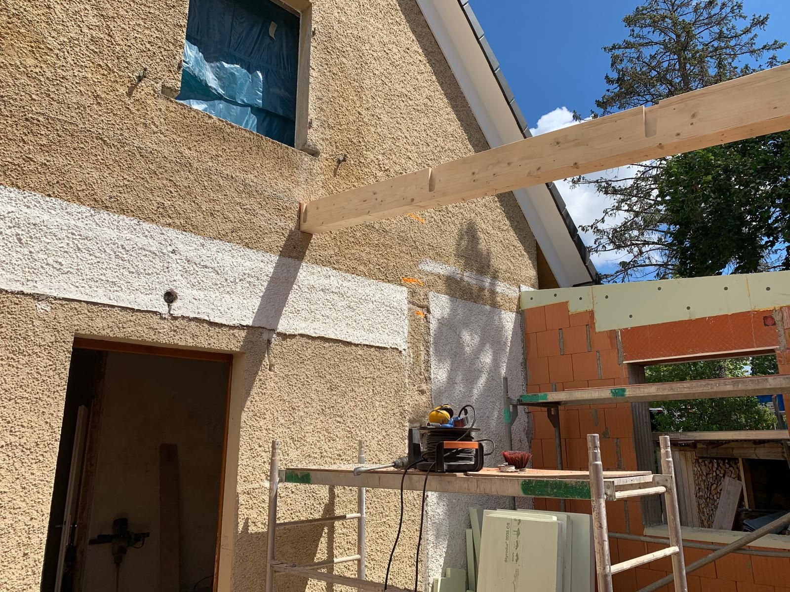 Montage der tragenden Holzbalken für einen Carport-Anbau an einem Wohnhaus