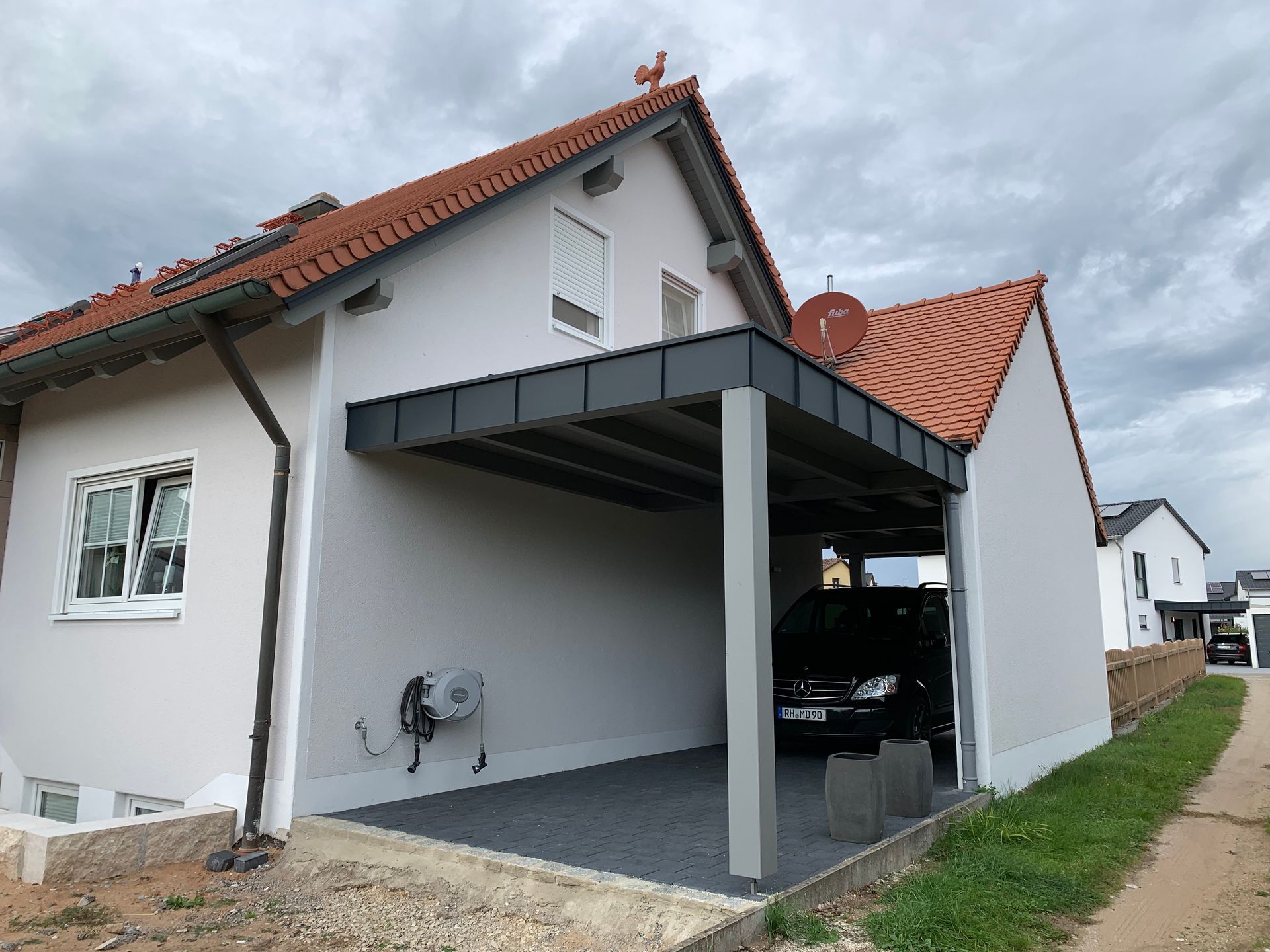 Fertig montierter Carport mit modernem Flachdach an einem Einfamilienhaus