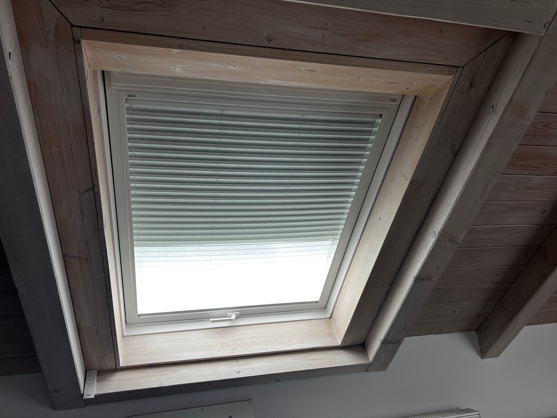 Dachfenster mit geschlossenem Plissee-Innenrollo in ausgebautem Dachgeschoss.