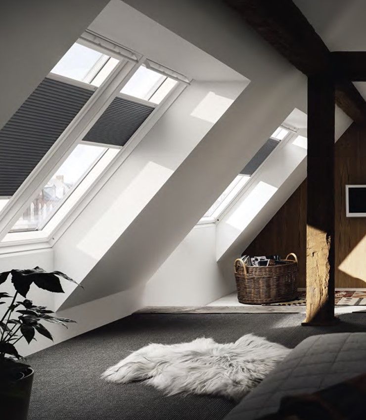 Große Dachfenster mit modernen Innenrollos in hellem Dachgeschoss.