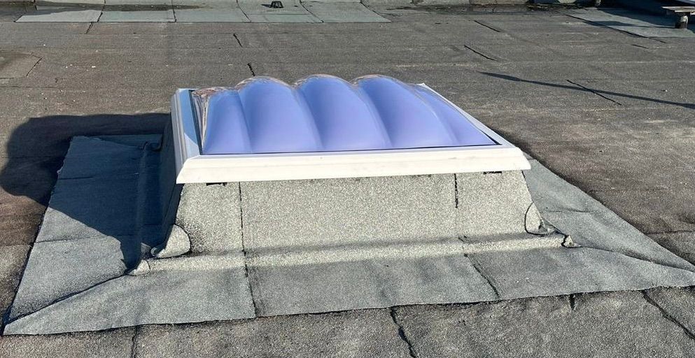 Gewölbte Lichtkuppel auf einem Flachdach zur natürlichen Belichtung eines Innenraums.