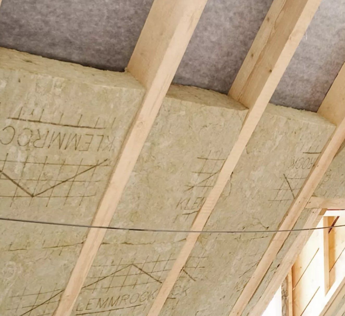 Holzbalkendecke im Innenausbau mit sichtbaren Sparren und dazwischen eingebrachter Mineralwolle-Dämmung.