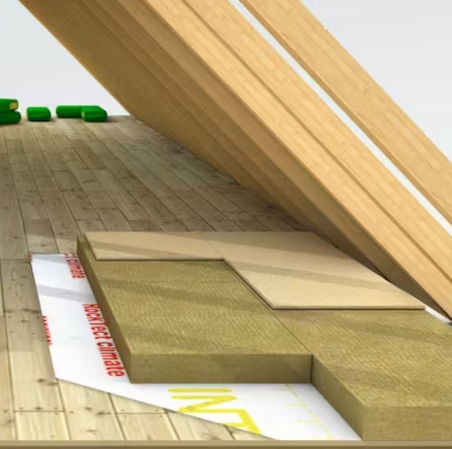 Schräg verlaufende Holzbalken einer Dachkonstruktion über einer Holzbodendecke