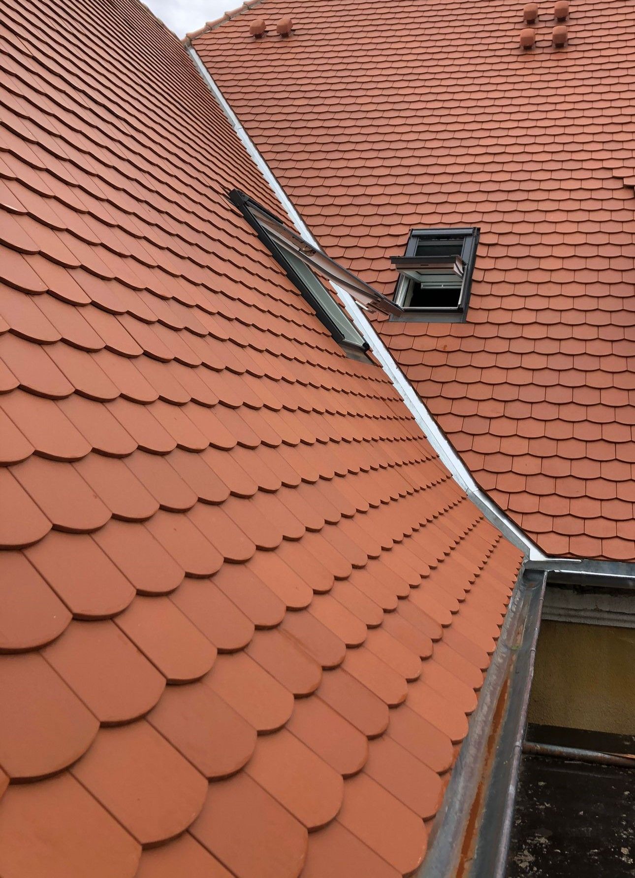 Dachfenster in einem Ziegeldach mit integrierter Regenrinne und Dachanschluss