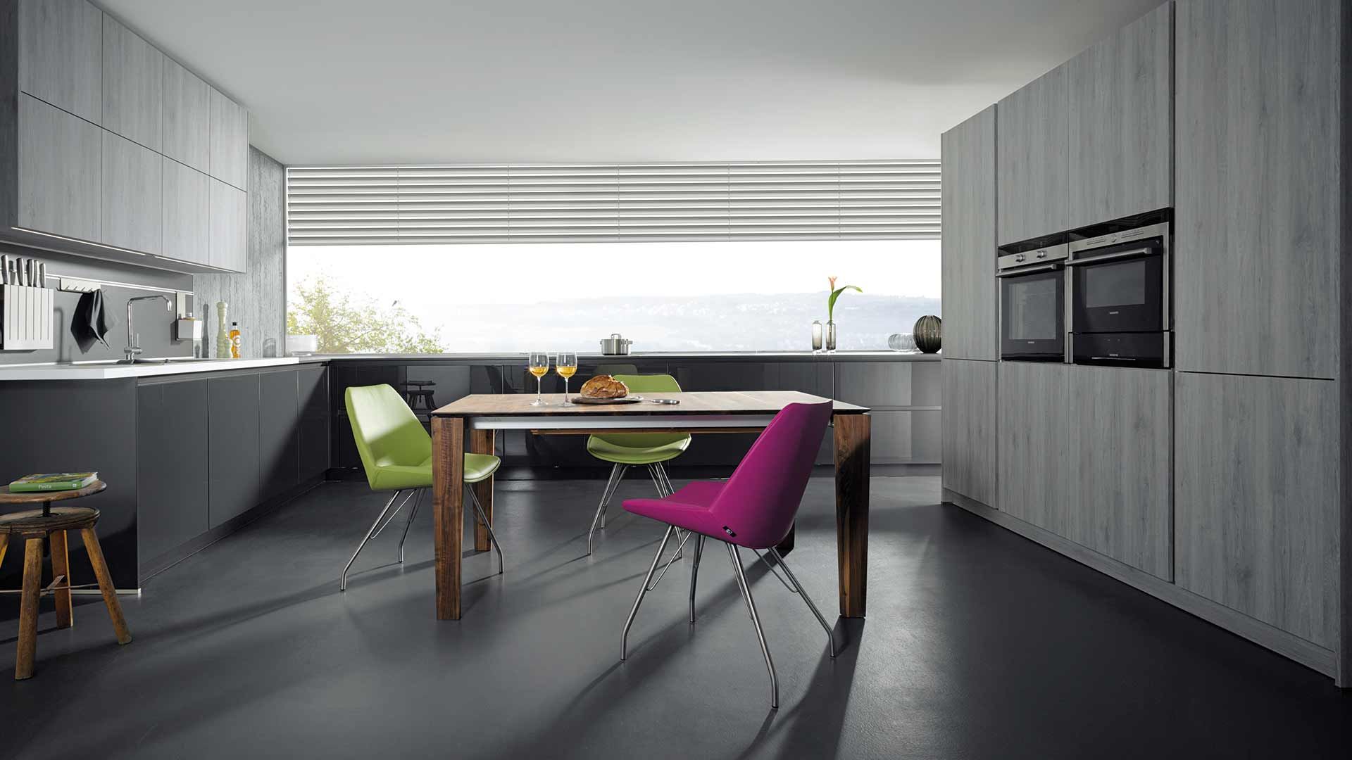 graue große Küche mit Essgarnitur in der Mitte