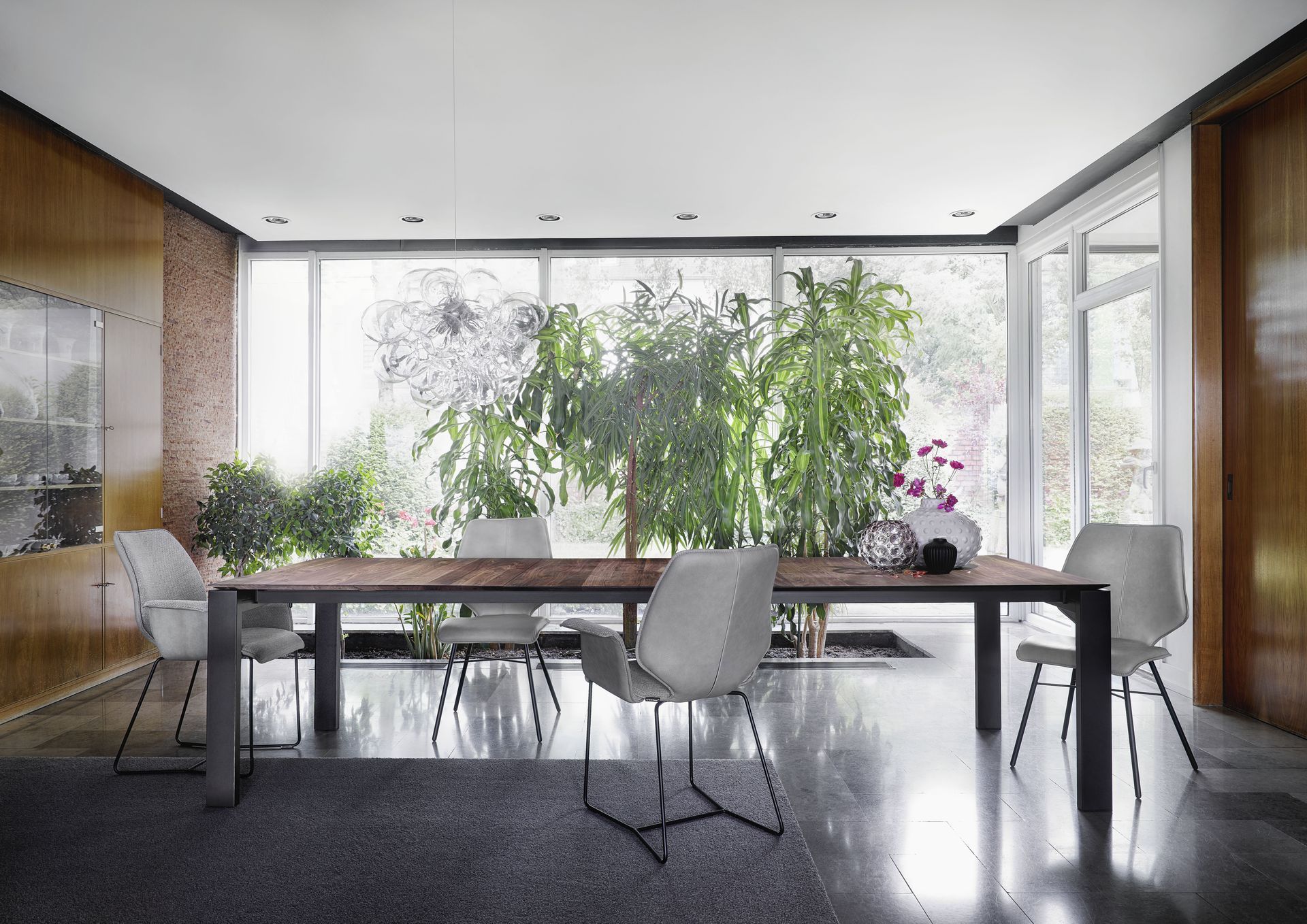 Esstisch mit Stühlen von Contur Einrichtungen vor einer Pflanzenoase