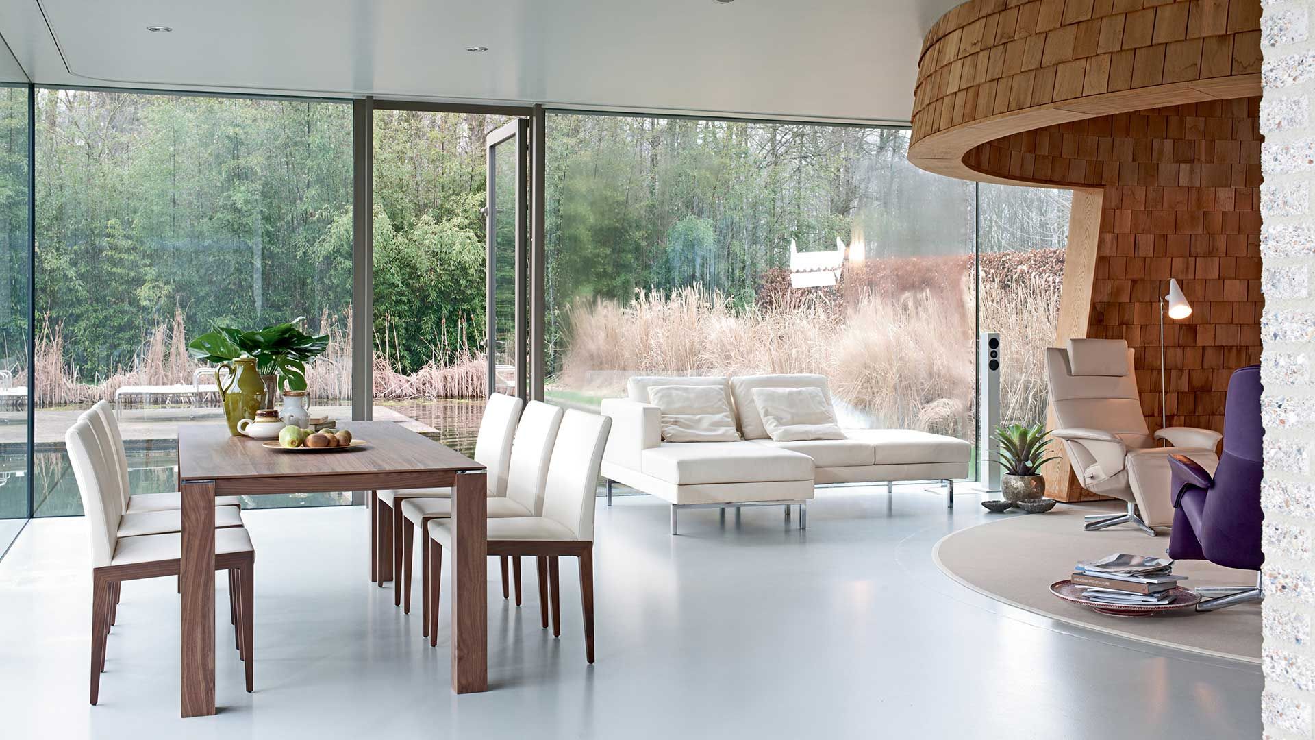 weiße Couch und Essgruppe von JORI vor einem großen Kamin