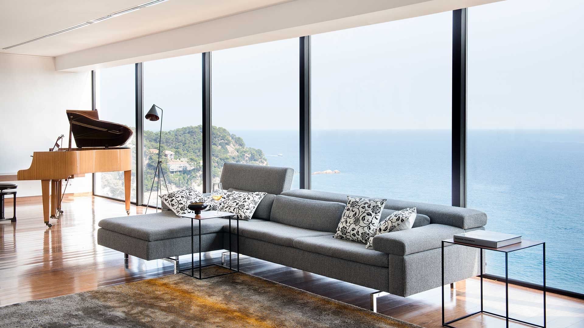 großes L-förmiges Sofa vor Fensterfront  von JORI