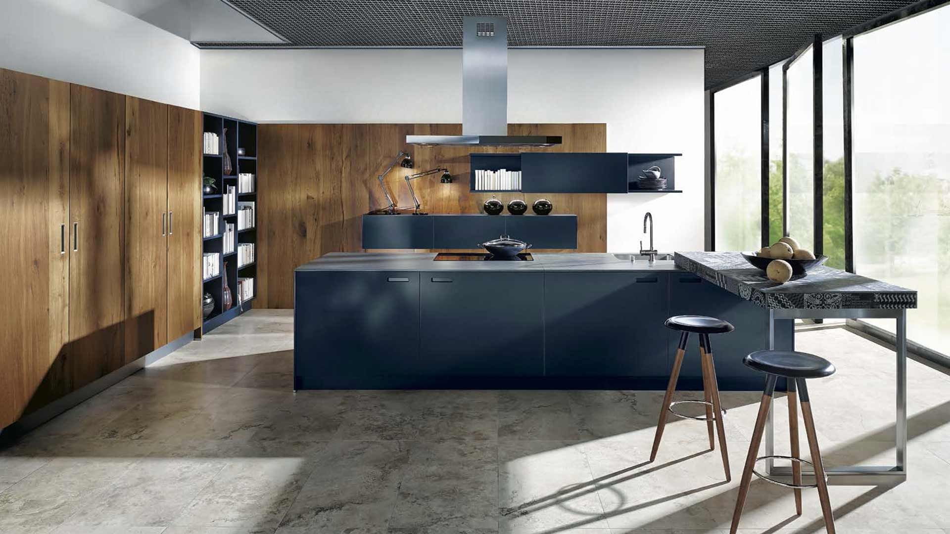freistehende dunkelblaue Kücheninsel und hölzerne Schrankwand im Hintergrund