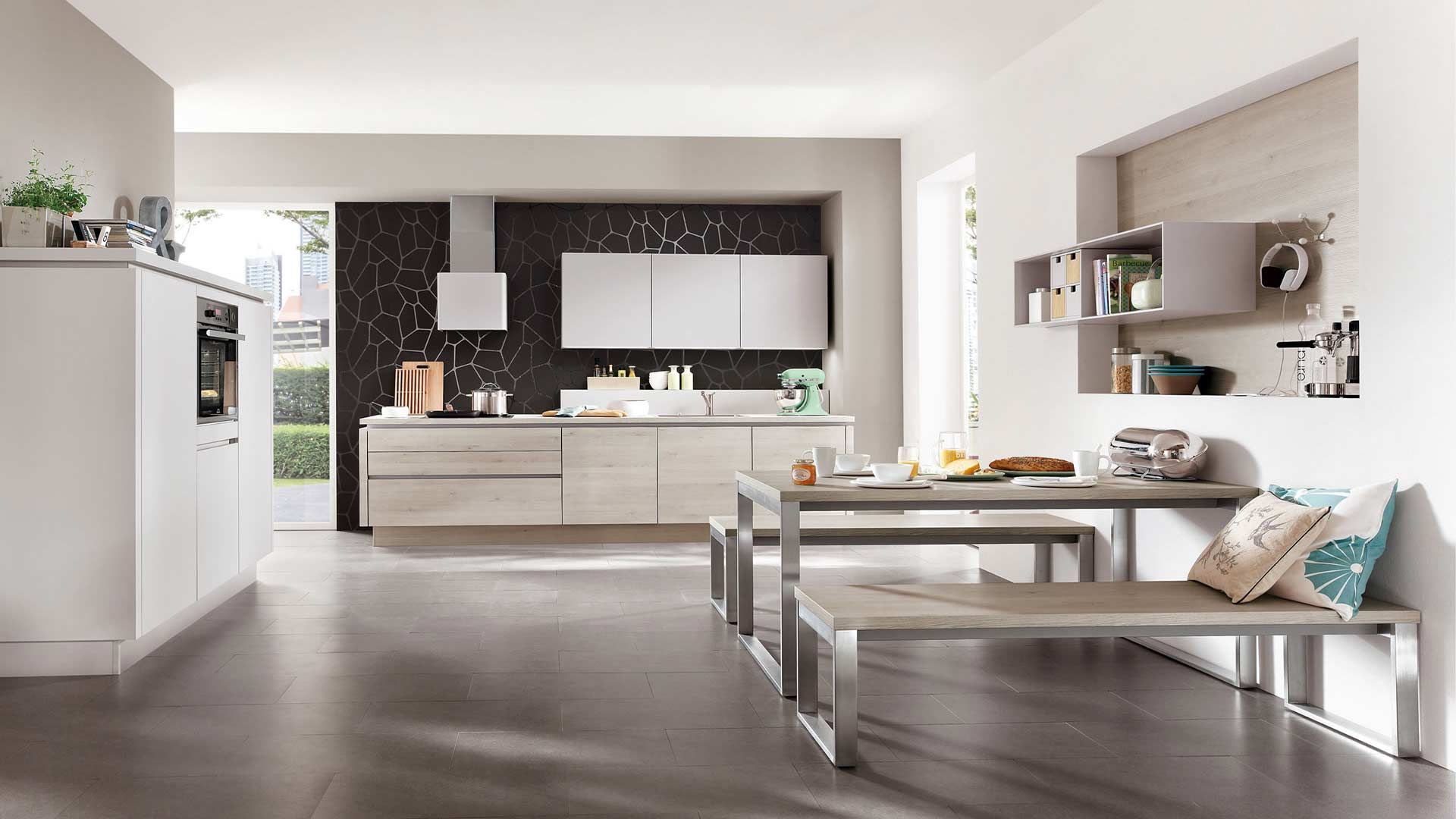 weiße offene Küche mit passender Sitzgarnitur von nobilia