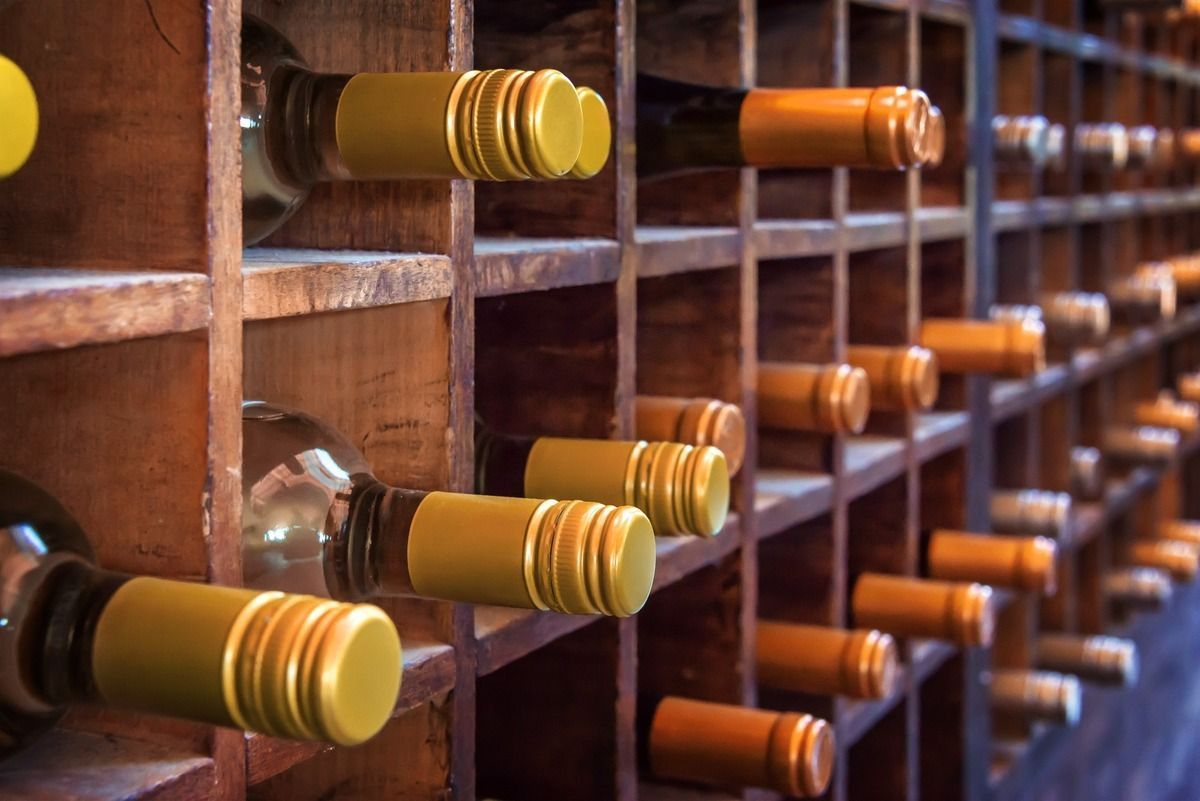 Muchas botellas de vino están alineadas en estantes de madera.