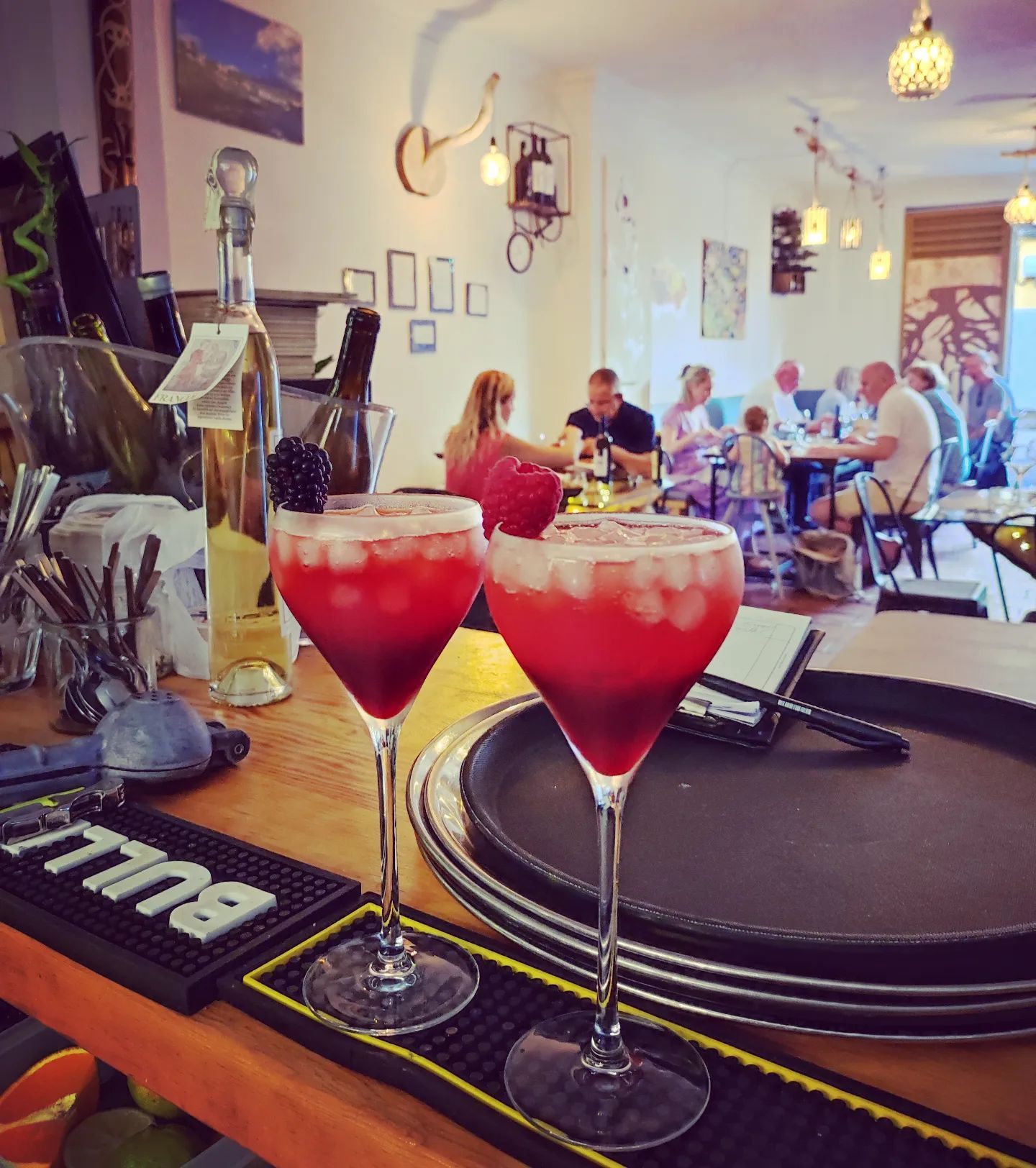 Dos copas de martini están sobre un tapete de bar que dice 