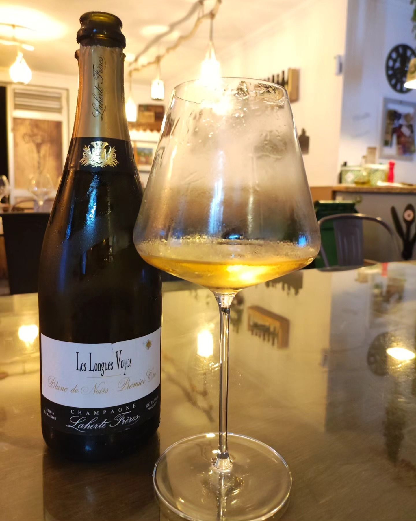 Una botella de vino de La Lagune junto a una copa de vino
