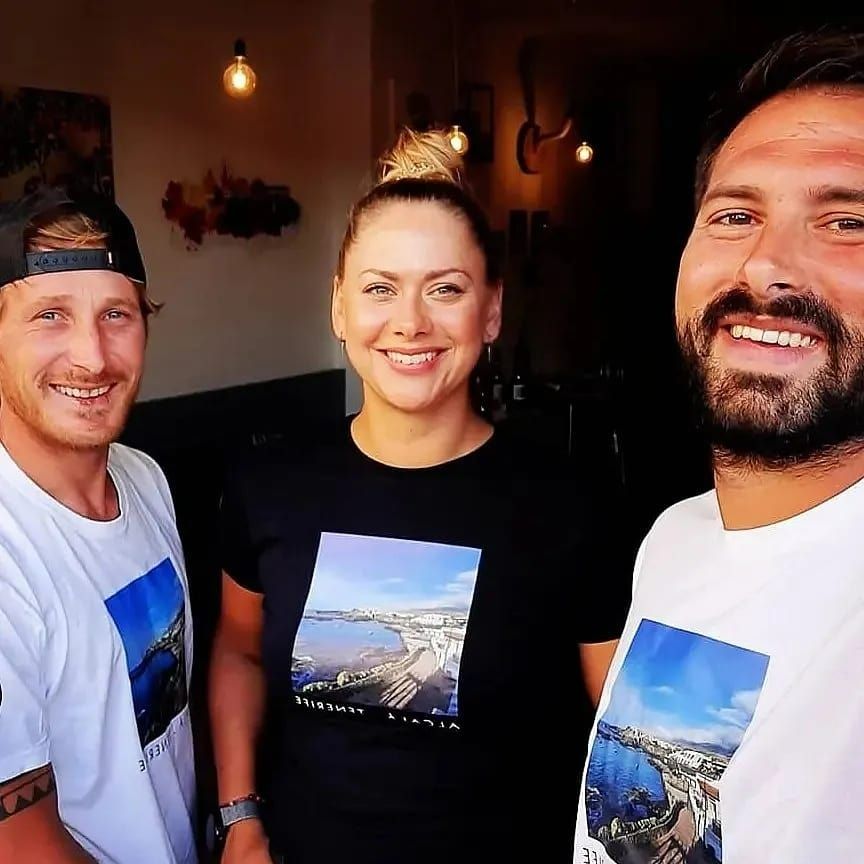 Dos hombres y una mujer posan juntos para una foto.
